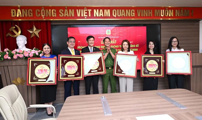 Thiếu tướng Vũ Văn Tấn, Cục trưởng Cục Cảnh sát QLHC về TTXH tặng quà lưu niệm cho các đơn vị đồng hành xây dựng Phòng họp thông minh và Phòng truyền thống số.