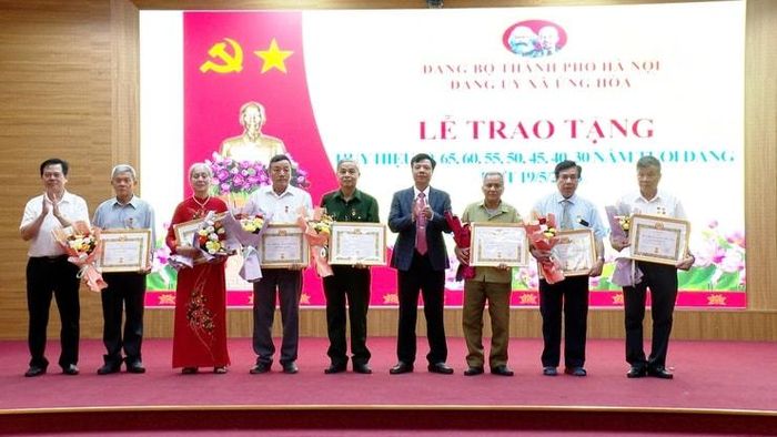 Lãnh đạo xã Ứng Hòa trao Huy hiệu Đảng tặng các đảng viên. Ảnh: Lê Quí