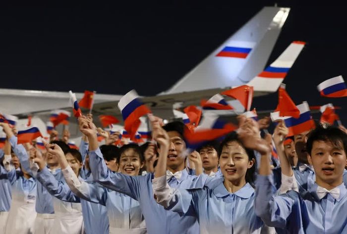 Thanh thiếu niên Trung Quốc vẫy cờ tại lễ đón Tổng thống Nga Vladimir Putin. Ảnh: Reuters.