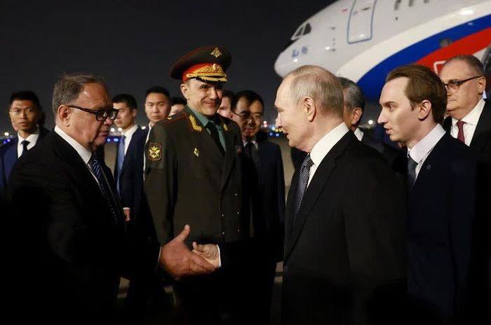 Tổng thống Nga Vladimir Putin bắt tay một quan chức tại lễ đón khi đến Bắc Kinh. Ảnh: Reuters.