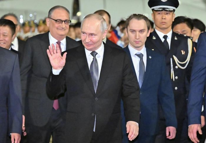 Tổng thống Nga Vladimir Putin cùng các quan chức Nga vẫy chào Bộ trưởng Ngoại giao Trung Quốc Vương Nghị đón ông tại sân bay Bắc Kinh. Ảnh: Tân Hoa Xã.