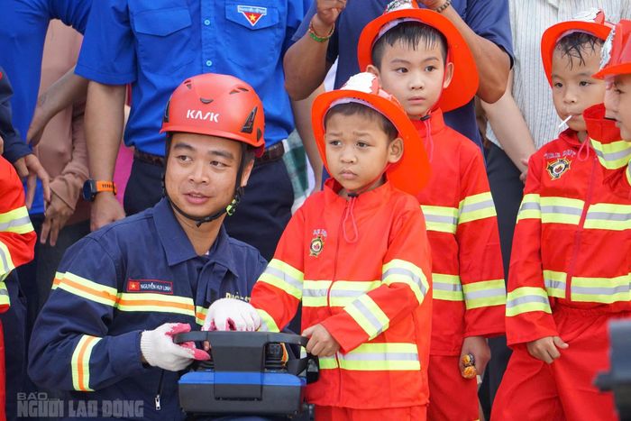 Thiếu tá Nguyễn Huy Linh, Đội trưởng Đội PCCC và CNCH, hướng dẫn A Lăng Hải Quan trải nghiệm thực hành chữa cháy