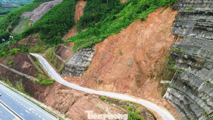  Theo ghi nhận của phóng viên, cả mảng lớn taluy dương tại nút giao vị trí Km29+700 tuyến cao tốc La Sơn - Hòa Liên với Tỉnh lộ 14B bị sạt lở khoét sâu, tạo thành vệt trượt đất đỏ kéo dài từ đỉnh đồi xuống mép đường dẫn. 