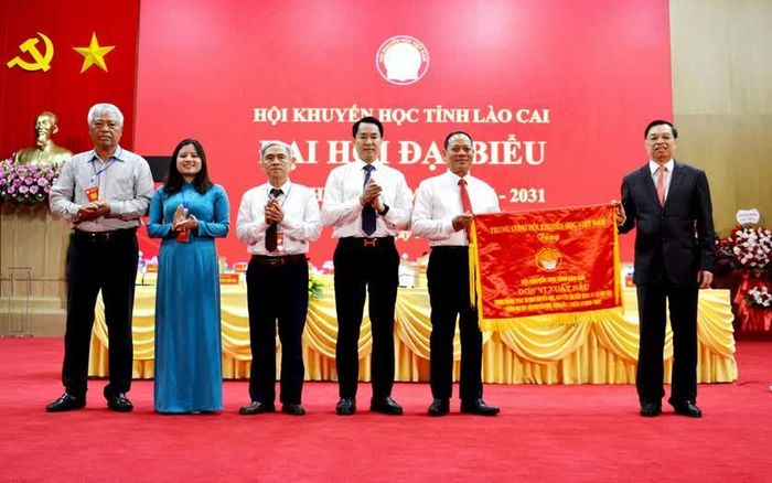 Phó Chủ tịch kiêm Tổng Thư ký Trung ương Hội Khuyến học Việt Nam Lê Mạnh Hùng trao tặng Cờ thi đua xuất sắc cho Hội Khuyến học tỉnh Lào Cai. Ảnh: Quốc Hồng