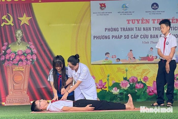 Nhân viên Trạm Y tế xã Vĩnh Thanh hướng dẫn các em học sinh kỹ năng sơ cứu khi gặp trường hợp đuối nước. Ảnh: PV