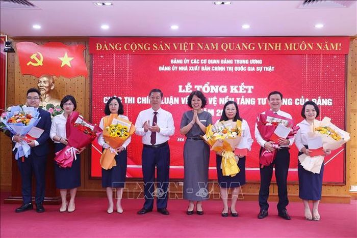 Đồng chí Nguyễn Thị Hoàng Vân, Phó Bí thư Đảng ủy các cơ quan Đảng Trung ương và PGS.TS. Vũ Trọng Lâm, Bí thư Đảng ủy, Giám đốc - Tổng Biên tập Nhà xuất bản Chính trị quốc gia Sự thật tặng hoa chúc mừng các tác giả có bài dự thi cấp Trung ương. Ảnh: Văn Điệp/TTXVN