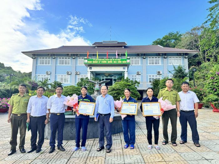 Ông Nguyễn Khắc Pho, Giám đốc Ban Quản lý Vườn Quốc gia Côn Đảo trao giấy khen cho ba công nhân vệ sinh môi trường.
