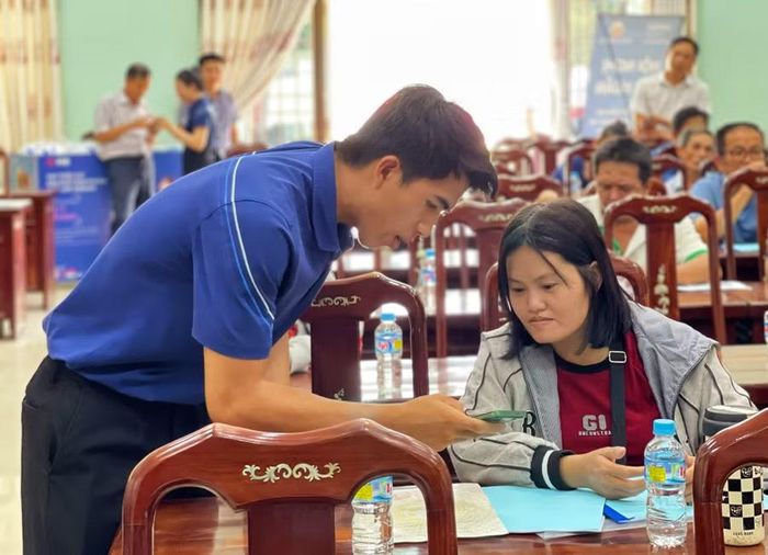 Nhân viên Viettel Gia Lai cài đặt sim điện thoại chính chủ cho tiểu thương chợ Phú Phong (xã Tây Sơn) để tạo mã QR. Ảnh: H.Y