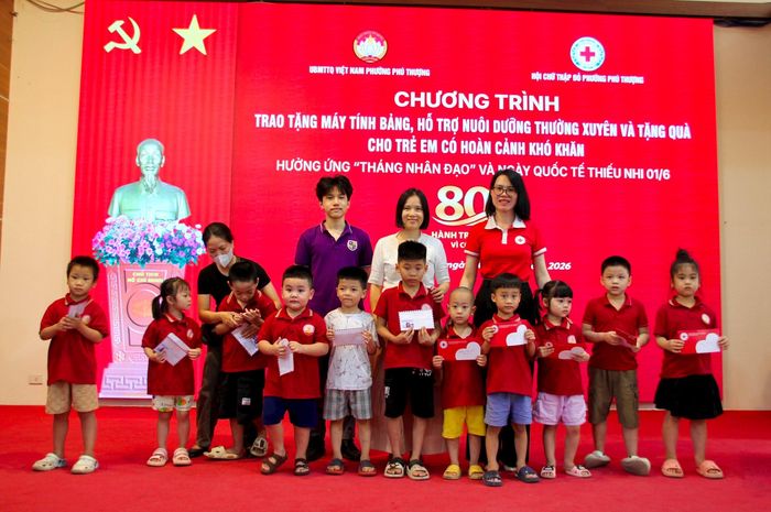 Chủ tịch Hội Chữ thập đỏ phường Phú Thượng Đỗ Thị Kim Ngân (áo đỏ) cùng nhà hảo tâm trao quà cho các trẻ em trên địa bàn phường. Ảnh: PV