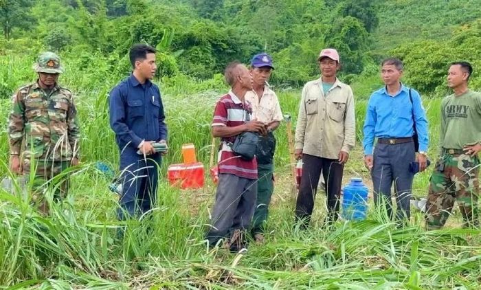 Các cán bộ, chiến sĩ Đội K73 trao đổi với người dân địa phương trước khi tiến hành thực hiện công việc tìm kiếm trên đất bạn Campuchia.