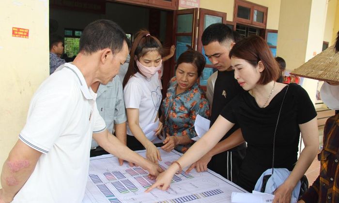 Sau khi bốc thăm, người dân phấn khởi tìm vị trí lô đất của gia đình trên bản đồ quy hoạch đất tái định cư sân bay Gia Bình.