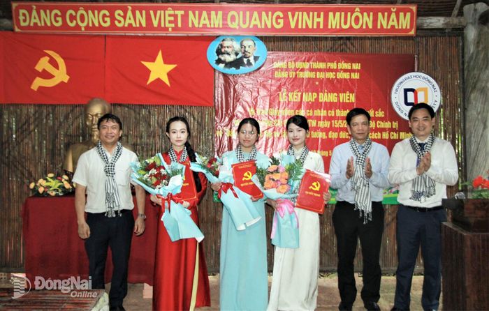 Đảng ủy, Ban giám hiệu nhà trường tặng hoa chúc mừng 3 đảng viên mới vừa được kết nạp. Ảnh: Nga Sơn