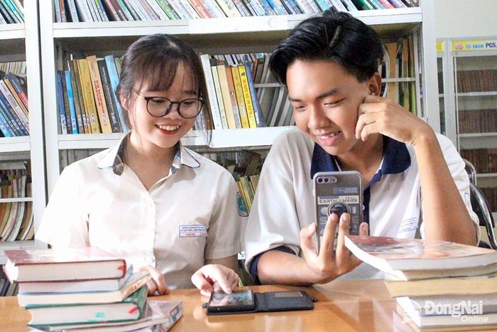 Học sinh trên địa bàn thành phố tra cứu tài liệu tại Thư viện Đồng Nai trên thiết bị thông minh có kết nối internet. Ảnh: My Ny