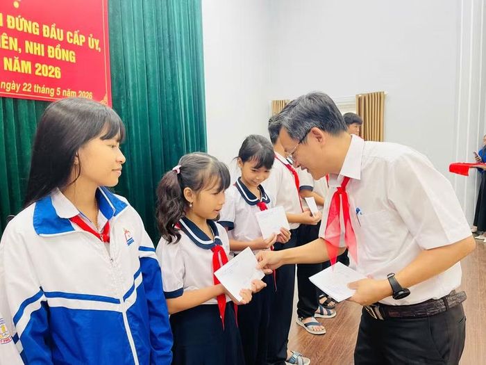 Chủ tịch UBND phường Ayun Pa Đặng Quang Khanh tặng quà cho các em học sinh tham gia hội nghị. Ảnh: Vũ Chi