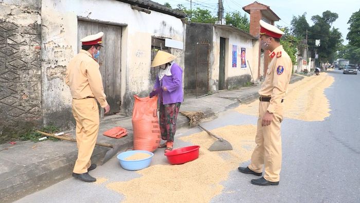 Lực lượng CSGT, Công an tỉnh Thanh Hóa nhắc nhở người dân không phơi thóc, lúa trên Quốc lộ 45, phường Đông Tiến.