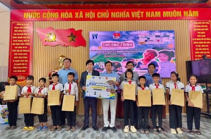 Đại diện lãnh đạo xã Phước Năng, Bệnh viện Răng Hàm Mặt Đà Nẵng cùng các đơn vị đồng hành trao quà chăm sóc răng miệng miễn phí và hỗ trợ học sinh.