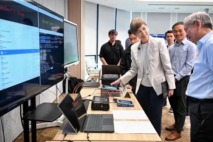 Bộ trưởng Josephine Teo trao đổi với Giám đốc điều hành CSA David Koh (phải) tại khu vực kỹ thuật bên lề một cuộc gặp các lực lượng phòng thủ mạng.