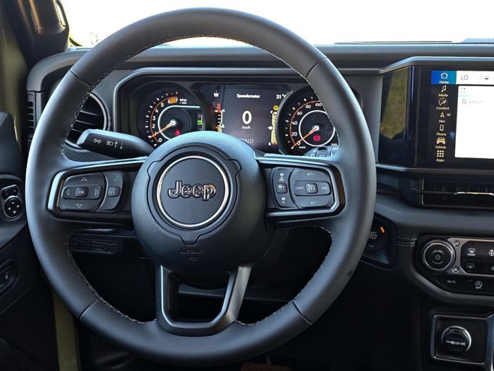  Vô lăng tròn 3 chấu trên Jeep Wrangler tích hợp các phím điều khiển chức năng, có thêm chức năng sưởi. 