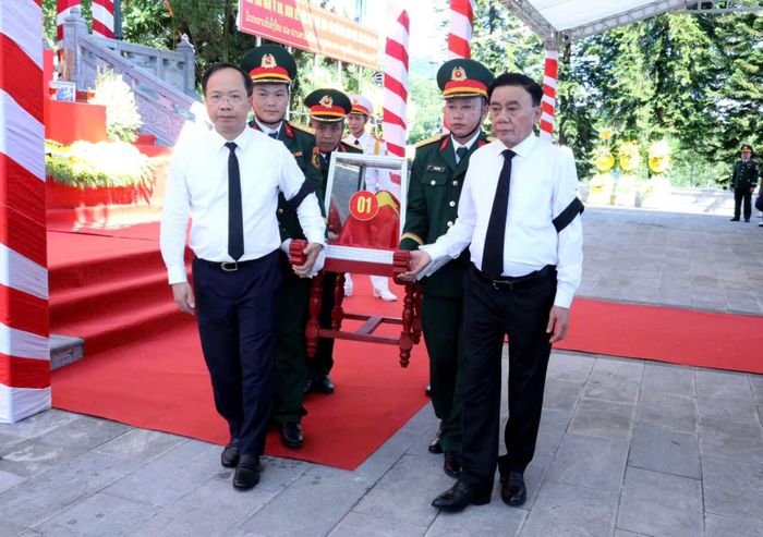 Thường trực Ban Bí thư Trần Cẩm Tú và Bí thư Tỉnh ủy Hà Tĩnh Nguyễn Duy Lâm đưa hài cốt các liệt sĩ về nơi yên nghỉ tại Nghĩa trang liệt sĩ Nầm. Ảnh: X.Sinh