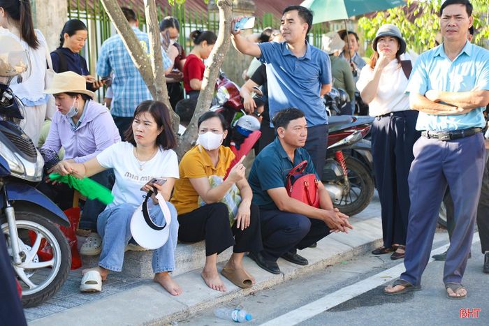 Dưới thời tiết nắng nóng gay gắt của Hà Tĩnh, chiếc quạt giấy, chai nước hay bóng râm nhỏ ven đường trở thành “điểm tựa” tạm thời cho phụ huynh trong thời gian chờ đợi.