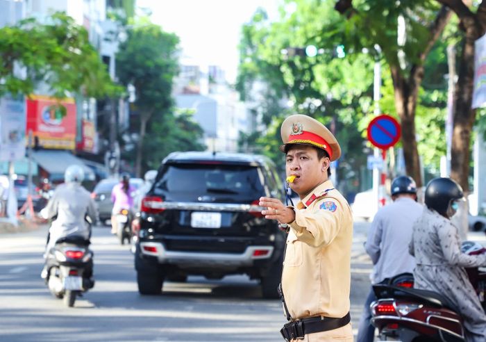 Đại úy Nguyễn Tấn Trọng (Phòng Cảnh sát giao thông, Công an thành phố) làm nhiệm vụ điều hòa giao thông tại điểm thi Trường THPT Phan Châu Trinh (phường Hải Châu). Ảnh: NGỌC PHÚ