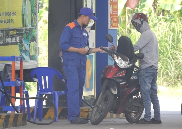 Nhân viên Công ty CP Xăng dầu Petrolimex Đà Nẵng thông tin cho người dân về lộ trình xăng E10. Ảnh: MAI QUẾ