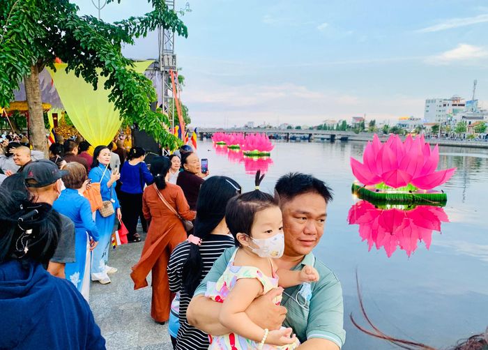 Người dân ngắm và chụp hình với những đóa hoa sen trên sông Cà Ty