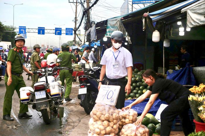 Nhiều trường hợp buôn bán hàng rong lấn chiếm vỉa hè, lòng đường quanh khu vực chợ đầu mối nông sản Thủ Đức bị lực lượng chức năng nhắc nhở, yêu cầu thu dọn để bảo đảm mỹ quan và an toàn giao thông. Ảnh: PHẠM HẢI