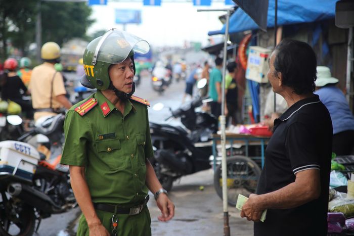 Công an phường Tam Bình phối hợp Đội CSGT Rạch Chiếc tuần tra, nhắc nhở người dân không lấn chiếm lòng lề đường để buôn bán quanh khu vực chợ đầu mối nông sản Thủ Đức trong đợt cao điểm bảo đảm trật tự đô thị. Ảnh: PHẠM HẢI