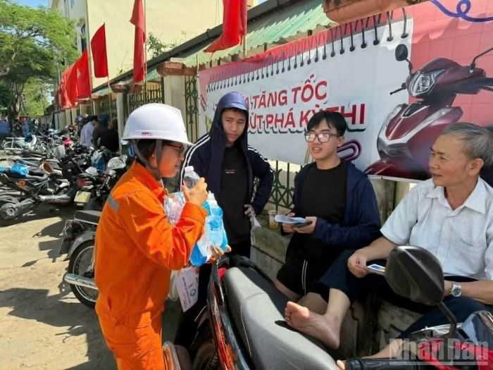 Phát nước uống cho người dân chờ con thi tuyển sinh lớp 10.