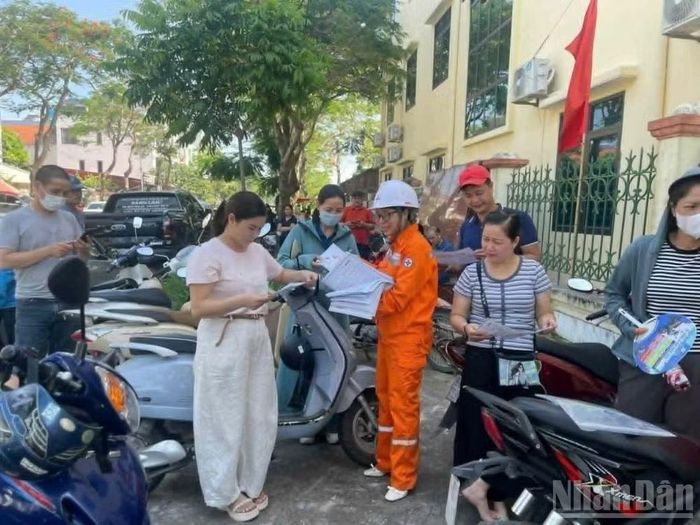 Phát tờ rơi tuyên truyền tiết kiệm điện trong cao điểm nắng nóng.