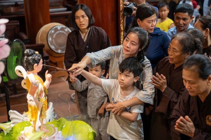  Nghi thức tắm Phật trong ngày Phật đản là cách Phật tử tưởng nhớ sự kiện Đức Phật ra đời, đồng thời nhắc mỗi người tự gột rửa thân tâm. Trong ảnh: Người dân đang thực hành nghi thức tắm Phật tại chùa Vân Gia - phường Sơn Tây, Hà Nội.