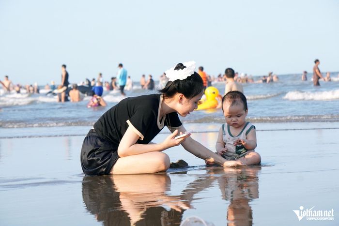 Cháu nhỏ thích thú nghịch cát trên bãi biển.