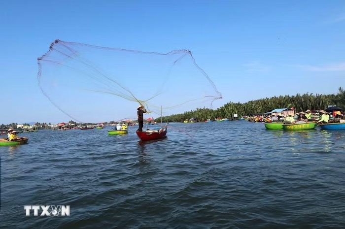 Người dân địa phương tái hiện cảnh quăng chài đánh cá để phục vụ du khách ở làng dừa Cẩm Thanh, một trong 50 ngôi làng đẹp nhất thế giới năm 2025. (Ảnh: Đỗ Trưởng/TTXVN)
