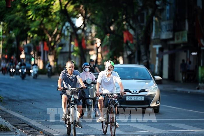 Người dân ra đường đạp xe tập thể dục từ sớm để trở về nhà cũng sớm hơn thường lệ. Ảnh: Phạm Tuấn Anh - TTXVN