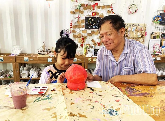 Bé Nguyễn Mai Vy thích thú trải nghiệm tô tượng cùng ông nội tại workshop thủ công cuối tuần ở phường Vĩnh Yên.