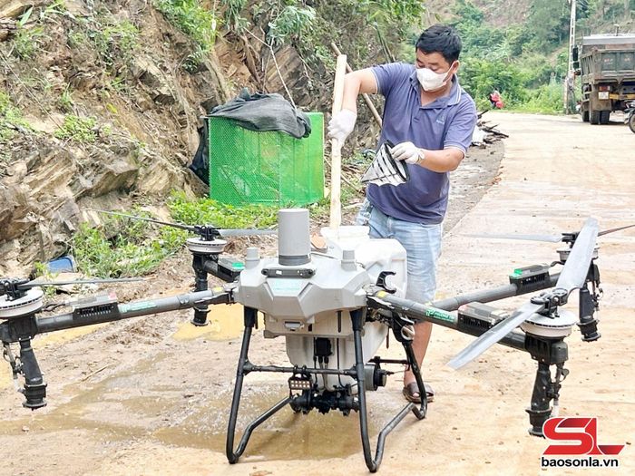 Nông dân Quàng Văn Nhất pha thuốc trừ sâu vào bình thiết bị bay chuẩn bị phun cho cây trồng.
