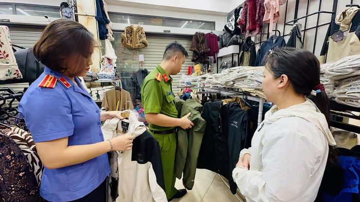 Lực lượng chức năng kiểm tra, thu giữ lô hàng giả nhãn hiệu của Vũ Thị Mận. (Ảnh: Bộ Công an).