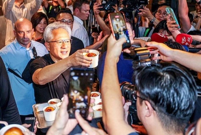  CEO Nvidia Jensen Huang phát đồ tráng miệng cho phóng viên và người hâm mộ chờ bên ngoài một nhà hàng ở Đài Bắc, Đài Loan, Trung Quốc, hôm 26/5. Ảnh: CNA. 