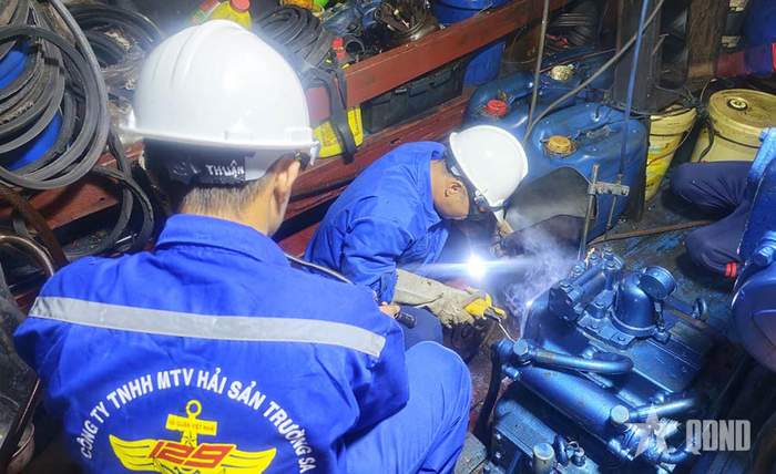 Nhân viên kỹ thuật của Hải đoàn 129 sửa chữa tàu cá ngư dân bị hỏng máy. 