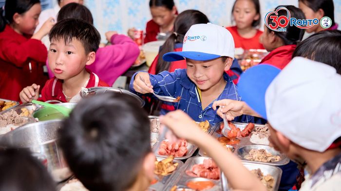 Các em học sinh tiểu học của trường Phổ thông Dân tộc Bán trú – Tiểu học số 1 Lùng Thẩn cùng thưởng thức bữa trưa “có thịt” do đoàn công tác tổ chức