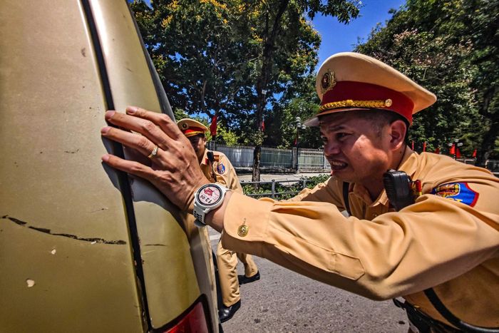 Dưới mặt đường bỏng rát và hơi nóng hầm hập từ bê tông, những chiến sĩ áo vàng vẫn liên tục làm nhiệm vụ giữa dòng phương tiện đông đúc của Thủ đô.