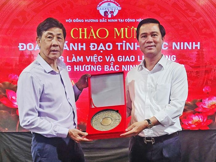  Đồng chí Lê Xuân Lợi tặng quà (sản phẩm đĩa di sản của tỉnh Bắc Ninh được UNESCO vinh danh) cho Chủ tịch Hội đồng hương Bắc Ninh. 