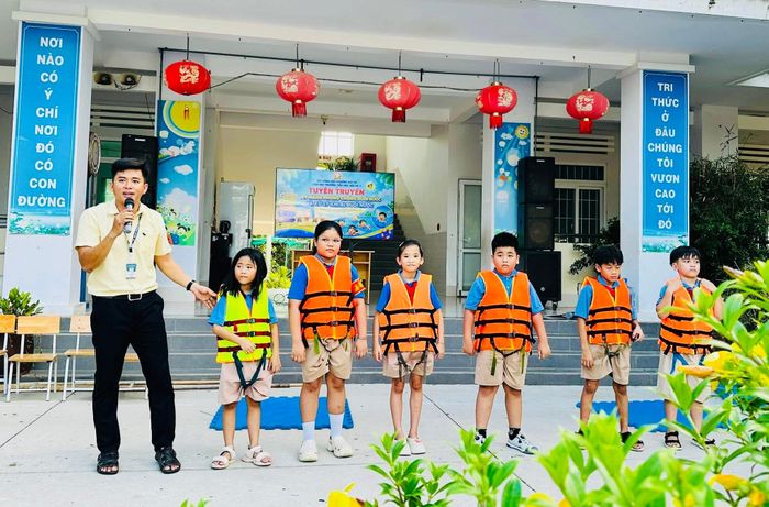 Giáo viên hướng dẫn học sinh mặc áo phao đúng cách