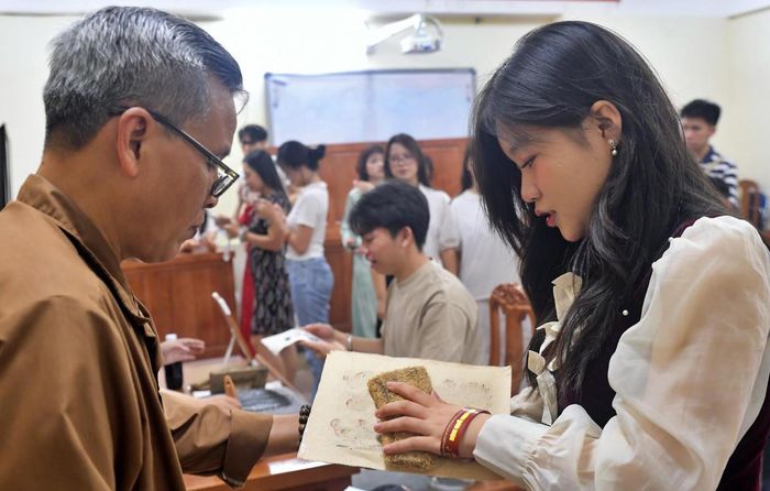 Nghệ nhân hướng dẫn bạn trẻ in tranh.