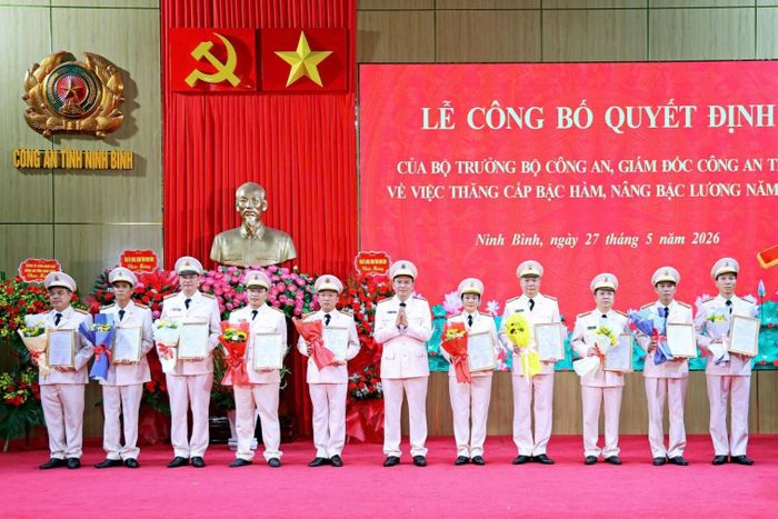 Đại tá Cù Quốc Thắng, Giám đốc Công an tỉnh Ninh Bình, trao Quyết định và tặng hoa chúc mừng đại diện các cán bộ được thăng cấp bậc hàm, nâng bậc lương. Ảnh: CANB 