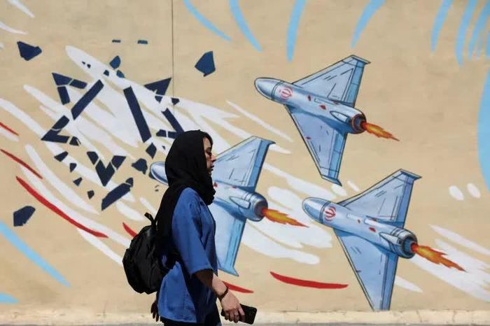  Một người phụ nữ ở Tehran đi bộ qua bức bích họa vẽ các máy bay không người lái của Iran vào ngày 26/5. Ảnh: Reuters. 