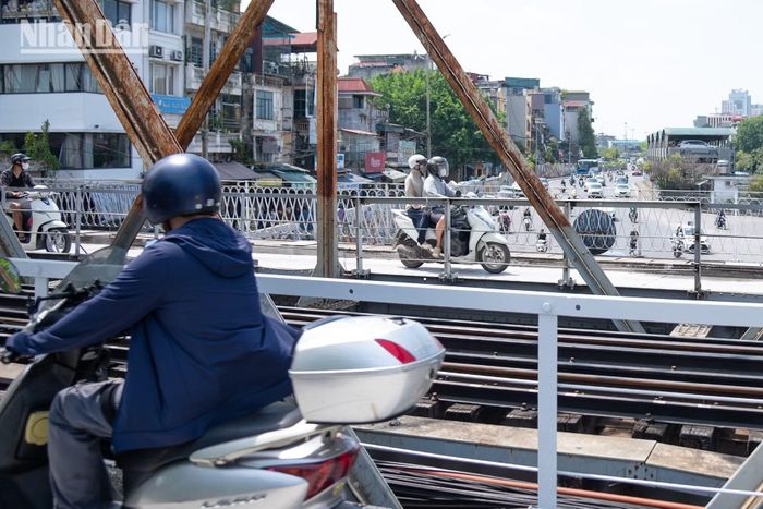 Sau nhiều ngày tạm lắng để "thay chiếc áo mới" sạch sẽ hơn, vững chãi hơn, cầu Long Biên tiếp tục sứ mệnh nối liền đôi bờ sông Hồng. Sau khi được khơi thông lại hoàn toàn, hai làm đường đã tấp nập bóng người và chuyến xe hàng, chở cả những niềm vui, tâm tư và hy vọng từ phía ngoại ô vào thành phố và ngược lại.