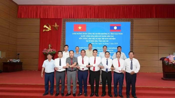 Các thành viên đoàn công tác hai địa phương chụp ảnh lưu niệm.