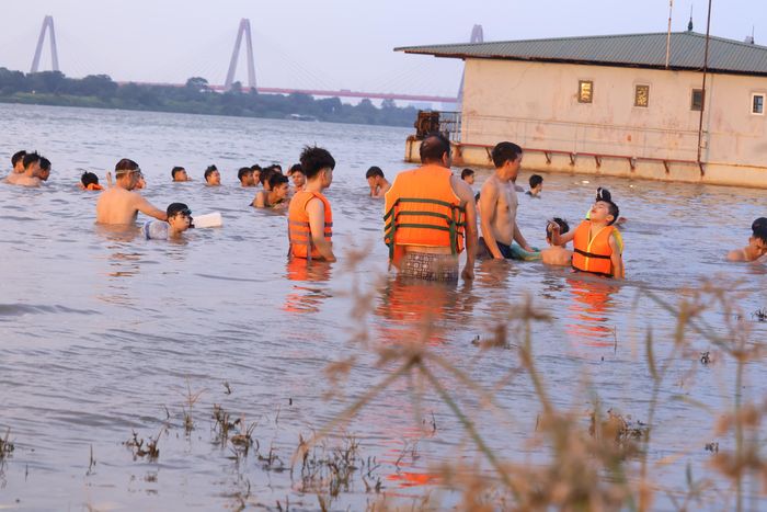 Từ đầu giờ chiều đến chiều muộn, hàng trăm người dân, trong đó có nhiều trẻ nhỏ, đổ về đây để tắm mát, tránh nóng.